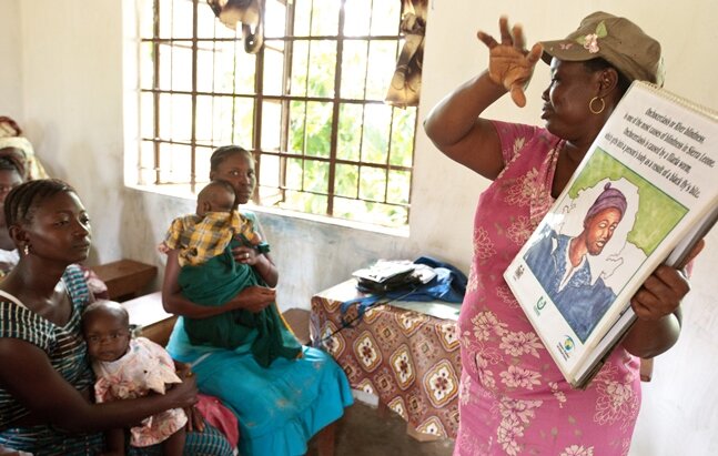 Community health officer Hawa Margai speaks about onchocerciasis to a group of women gathered at the Levuma community health center in the town of Levuma, Sierra Leone on Friday July 13, 2012.